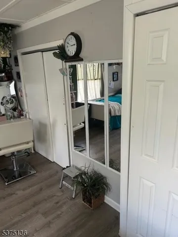 a view of a hallway with wooden floor and a window