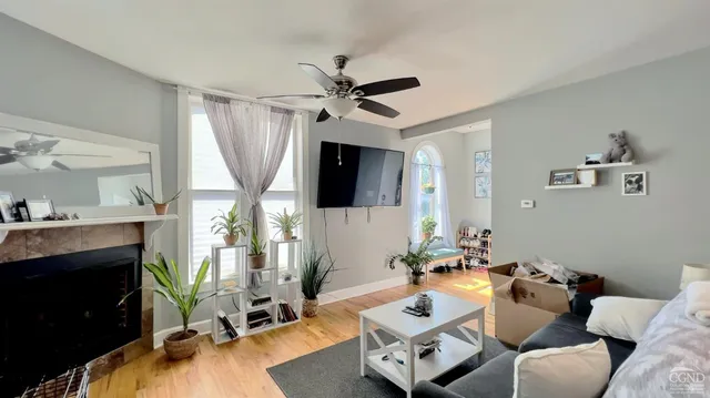 a living room with furniture a fireplace and a flat screen tv