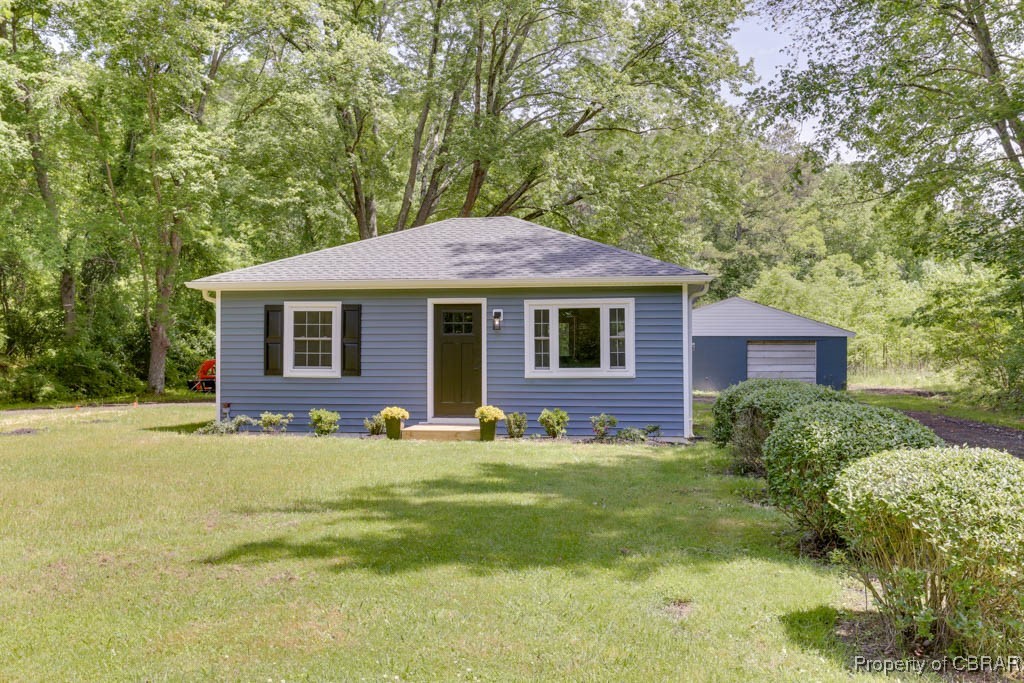 917 Chapel Neck Road North, VA 23128 - Photo 1 of 29 View of front of home with a detached garage, an outdoor structure, a front yard, and a shingled roof