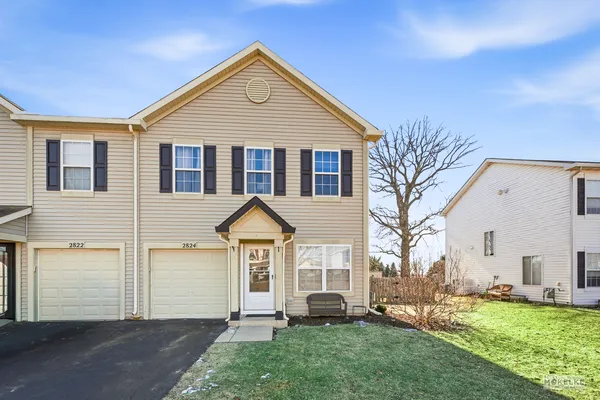 a front view of a house with a yard and trees