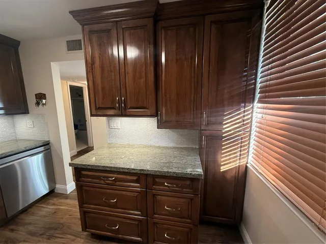 a bathroom with a granite countertop sink a toilet and shower