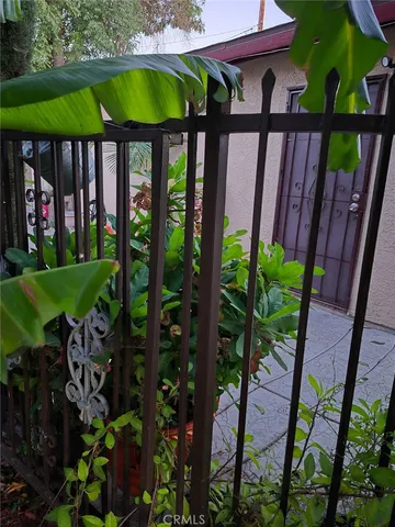 a view of a patio with table and chairs potted plants and floor to ceiling window