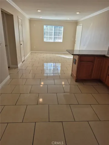 a view of a livingroom with kitchen and window