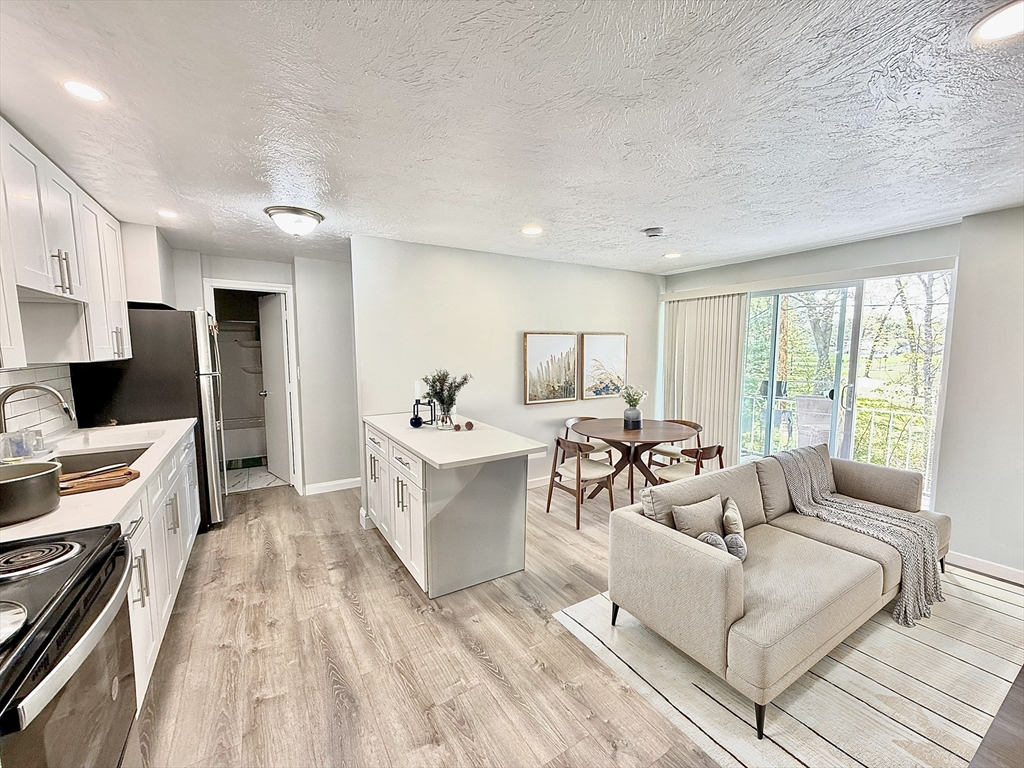 301 Grant Street, Unit 13 Framingham, MA 01702 - Photo 1 of 8 a living room with furniture and a large window