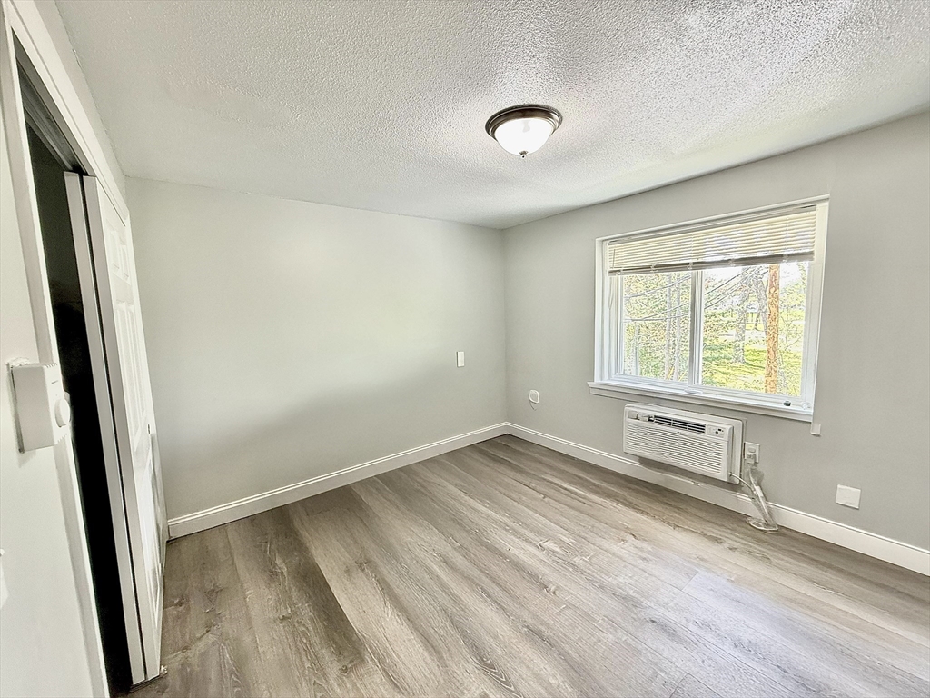 301 Grant Street, Unit 13 Framingham, MA 01702 - Photo 7 of 8 an empty room with wooden floor and windows