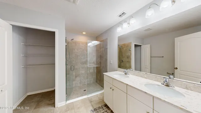 a bathroom with a shower tub double vanity and a mirror
