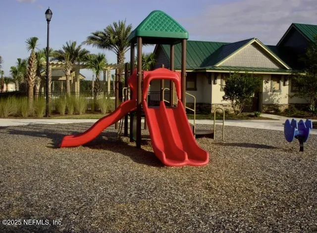 a view of a house with a yard potted plants and palm tree