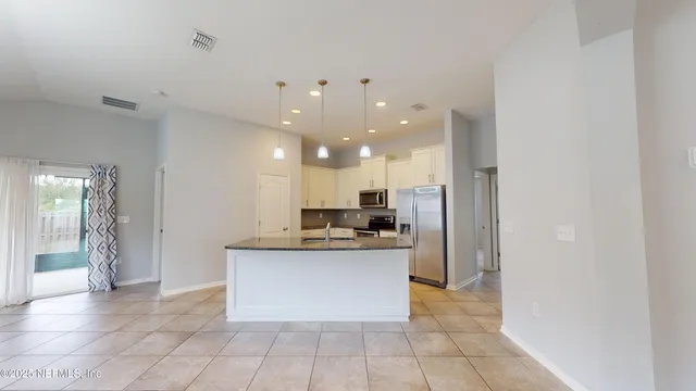 a kitchen with stainless steel appliances a refrigerator and a stove top oven