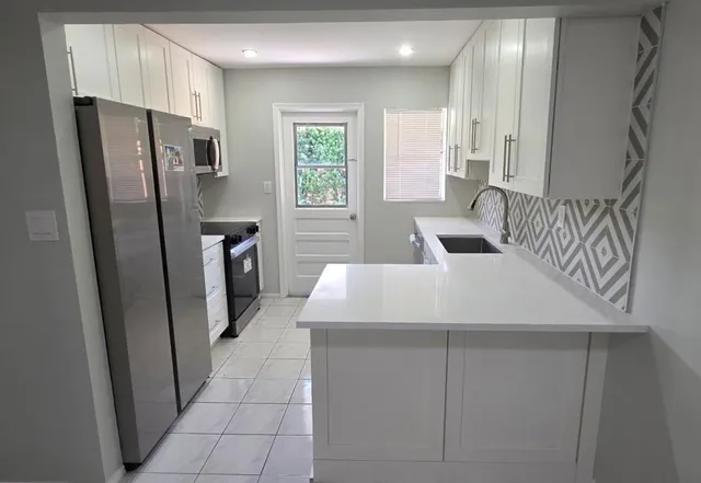 a kitchen with stainless steel appliances a refrigerator sink and cabinets
