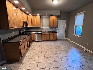 a kitchen with stainless steel appliances a sink stove and cabinets