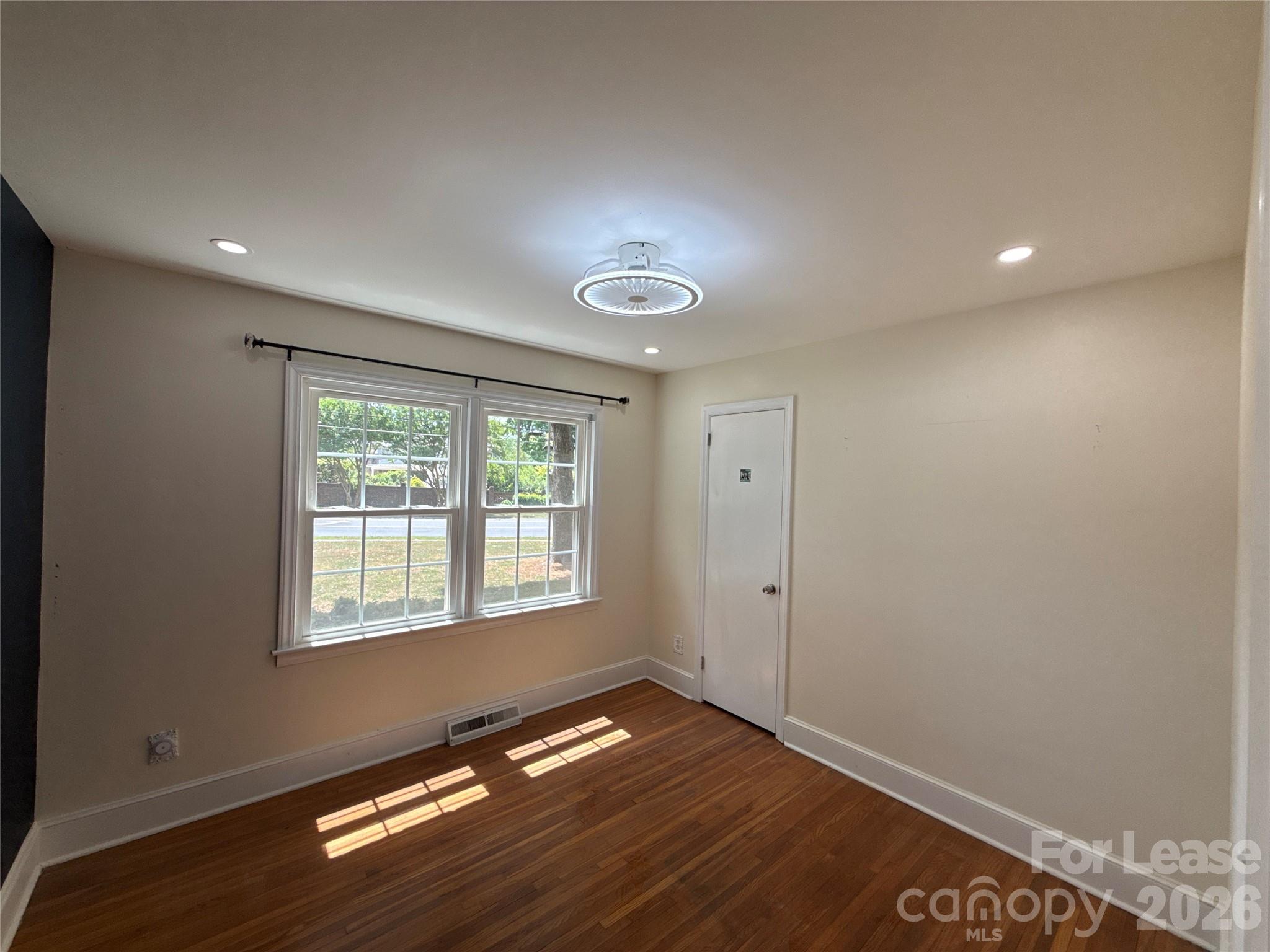 3927 Sharon View Road Charlotte, NC 28226 - Photo 13 of 14 a view of empty room with wooden floor and fan