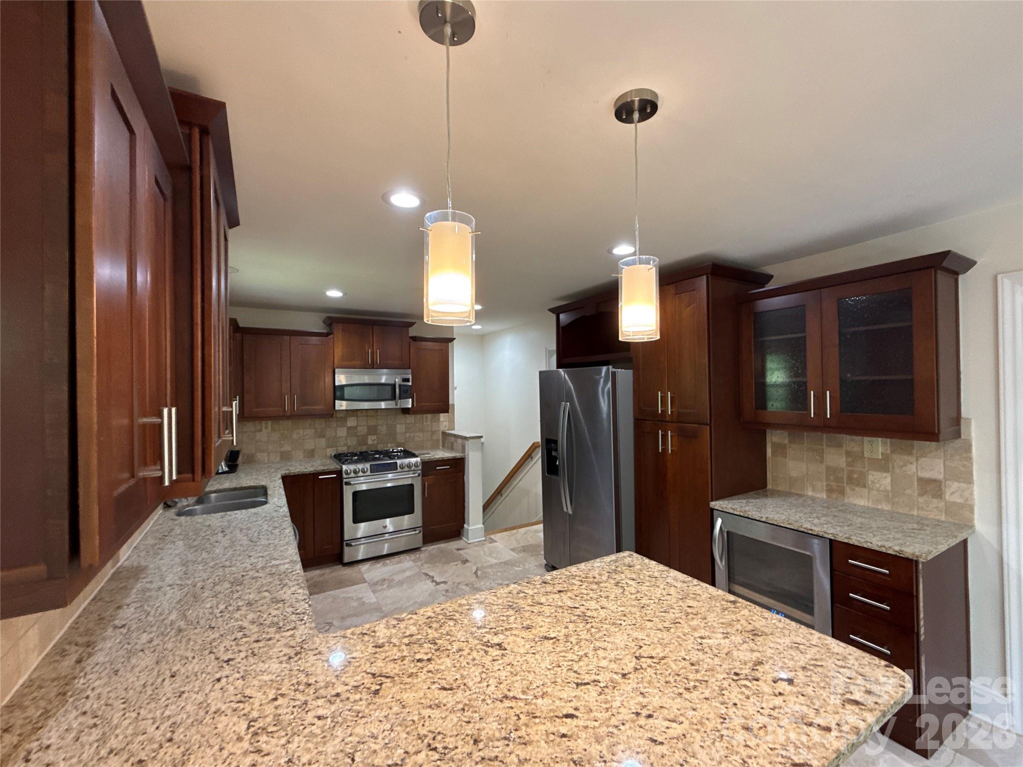 3927 Sharon View Road Charlotte, NC 28226 - Photo 5 of 14 a kitchen with stainless steel appliances kitchen island granite countertop a refrigerator a stove a oven a sink with a dining table and chairs