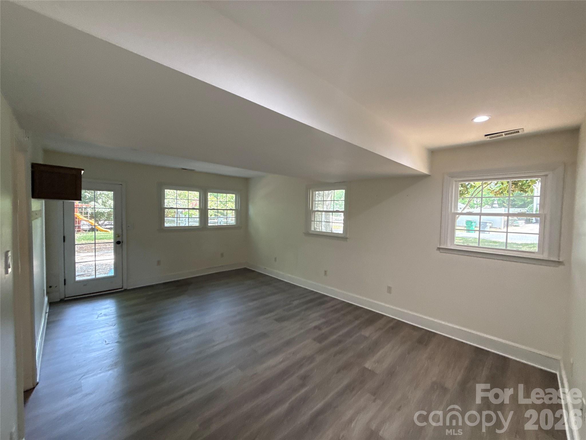 3927 Sharon View Road Charlotte, NC 28226 - Photo 10 of 14 a view of an empty room with wooden floor and a window