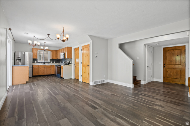 1346 Archmore Drive Springville, UT 84663 - Photo 5 of 32 Spacious main living area featuring wide-plank wood-finish flooring, a kitchen with stainless steel appliances, light wood cabinetry, and dark countertops