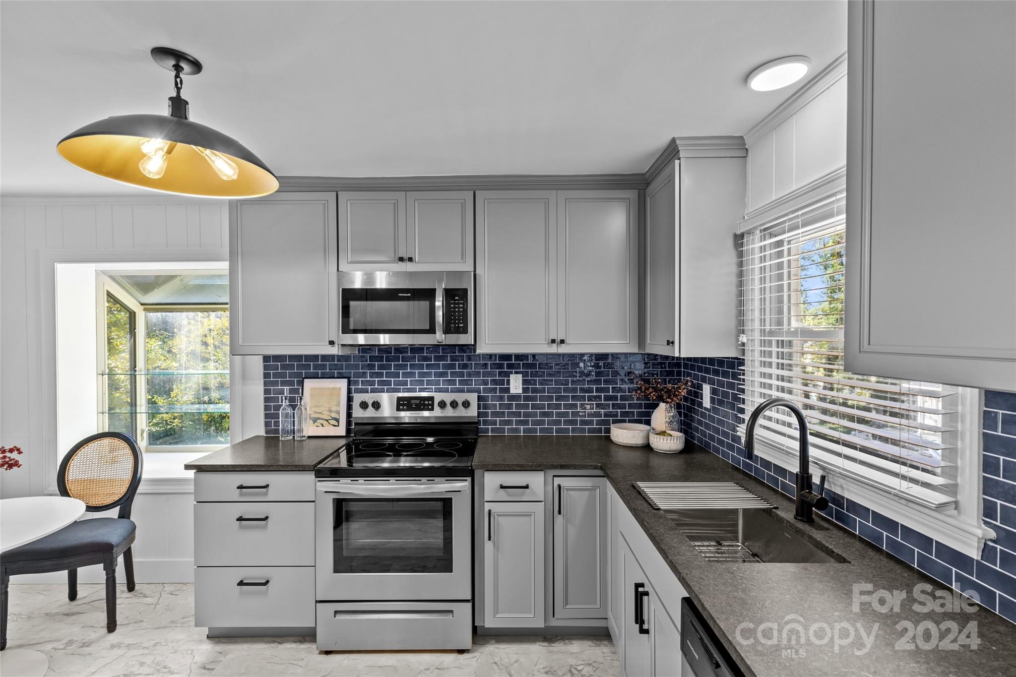 1639 Merry Oaks Road Charlotte, NC 28205 - Photo 13 of 47 a kitchen with stainless steel appliances granite countertop a stove a sink and a microwave