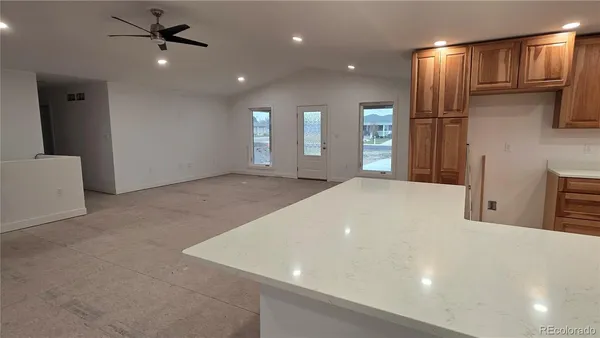 a large kitchen with stainless steel appliances a large counter top a refrigerator and a sink