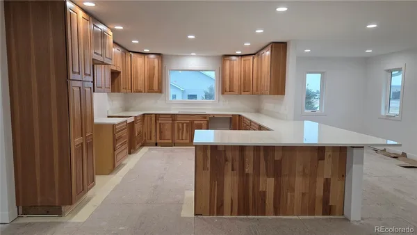 a kitchen with stainless steel appliances kitchen island granite countertop a refrigerator and a sink