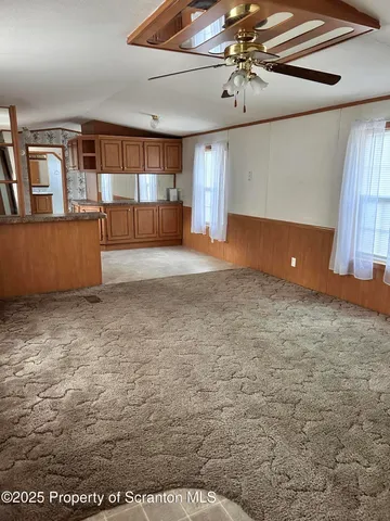 a view of a livingroom with furniture and chandelier fan