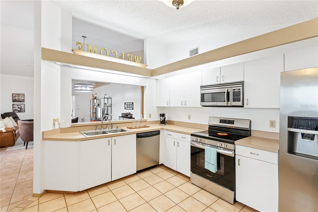 4537 South Lockwood Ridge Road Sarasota, FL 34231 - Photo 8 of 22 a kitchen with stainless steel appliances granite countertop a sink and cabinets