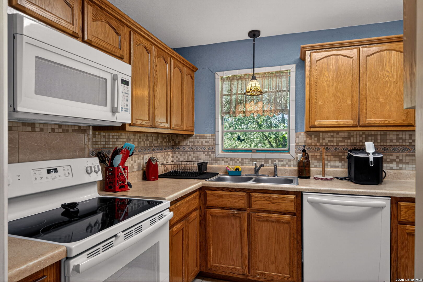 15505 Bradley Road Atascosa, TX 78002 - Photo 7 of 25 a kitchen with stainless steel appliances a sink a stove a refrigerator and cabinets