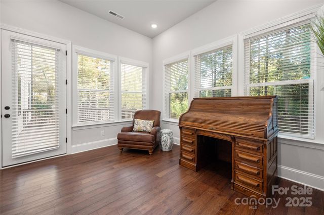 a living room with furniture a flat screen tv and wooden floor