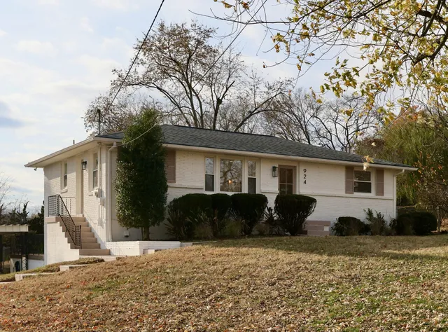 a front view of house with yard and trees in the background