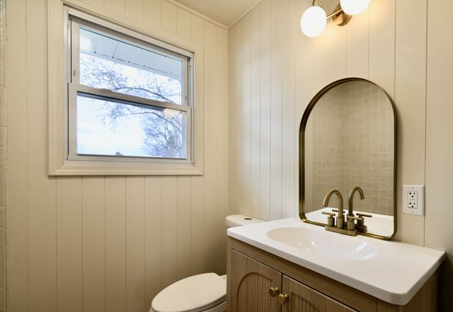 a bathroom with a sink mirror and toilet