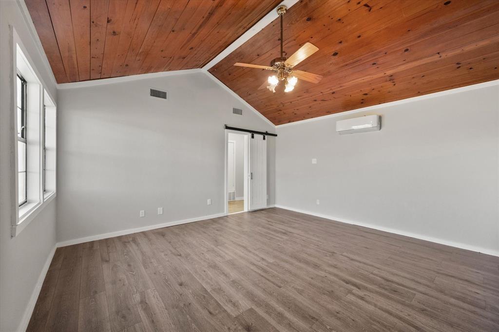 443 County Road 3799 Springtown, TX 76082 - Photo 21 of 33 Unfurnished room featuring a barn door, wooden ceiling, wood finished floors, ceiling fan, and a wall mounted AC
