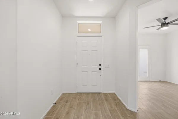 an empty room with wooden floor cabinet and door