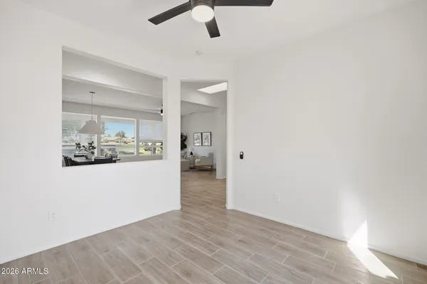 an empty room with a window and a fan