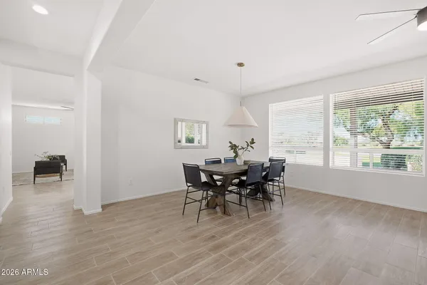 a kitchen with stainless steel appliances kitchen island granite countertop a stove a sink a dining table and chairs with wooden floor