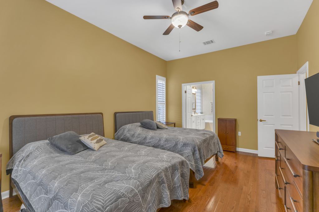 144 Cattle Trail Way Georgetown, TX 78633 - Photo 14 of 37 Hardwood floors and ample natural light fill this inviting bedroom, featuring direct access to a private bath.