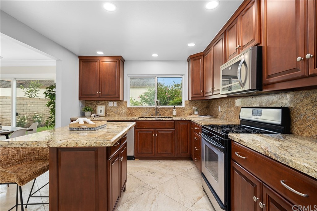4091 Germainder Way Irvine, CA 92612 - Photo 11 of 47 a kitchen with stainless steel appliances granite countertop a stove a sink and a microwave
