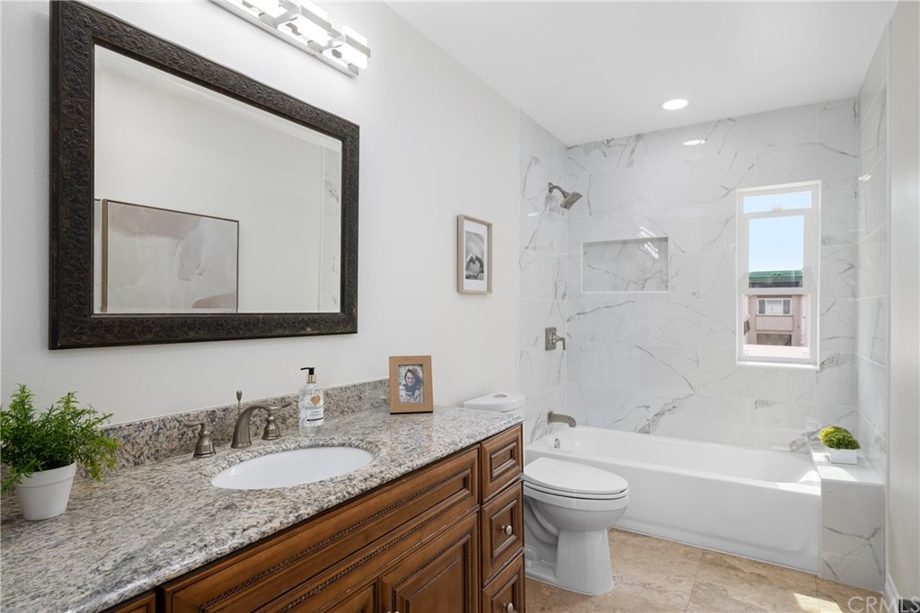 4091 Germainder Way Irvine, CA 92612 - Photo 25 of 47 a bathroom with a granite countertop sink toilet and a bathtub