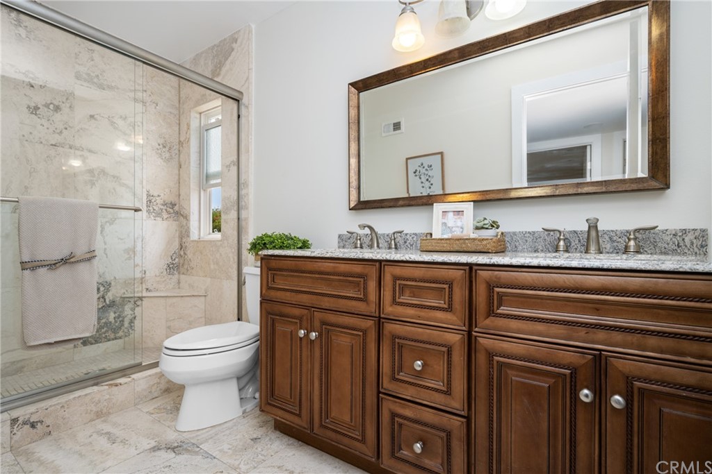 4091 Germainder Way Irvine, CA 92612 - Photo 28 of 47 a bathroom with a granite countertop sink toilet mirror and shower