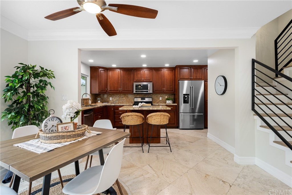 4091 Germainder Way Irvine, CA 92612 - Photo 6 of 47 a kitchen with stainless steel appliances kitchen island granite countertop a refrigerator a stove a sink dishwasher with a dining table and chairs