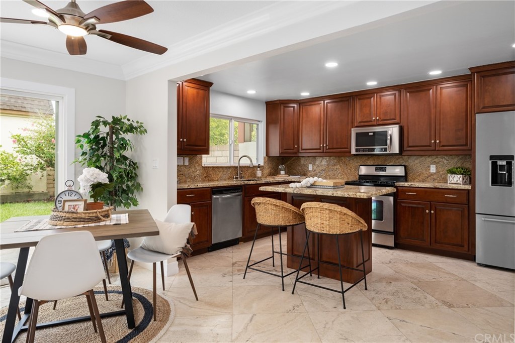 4091 Germainder Way Irvine, CA 92612 - Photo 8 of 47 a kitchen with stainless steel appliances granite countertop a stove a sink a microwave a refrigerator and chairs