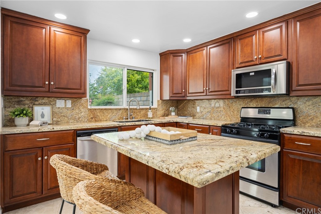 4091 Germainder Way Irvine, CA 92612 - Photo 10 of 47 a kitchen with granite countertop a stove sink and microwave