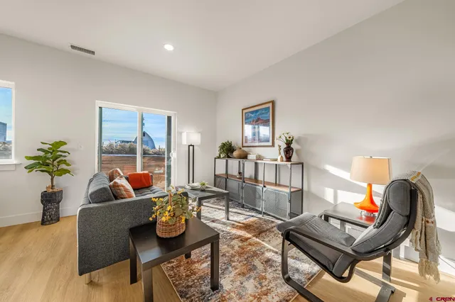 a living room with furniture a flat screen tv and a large window