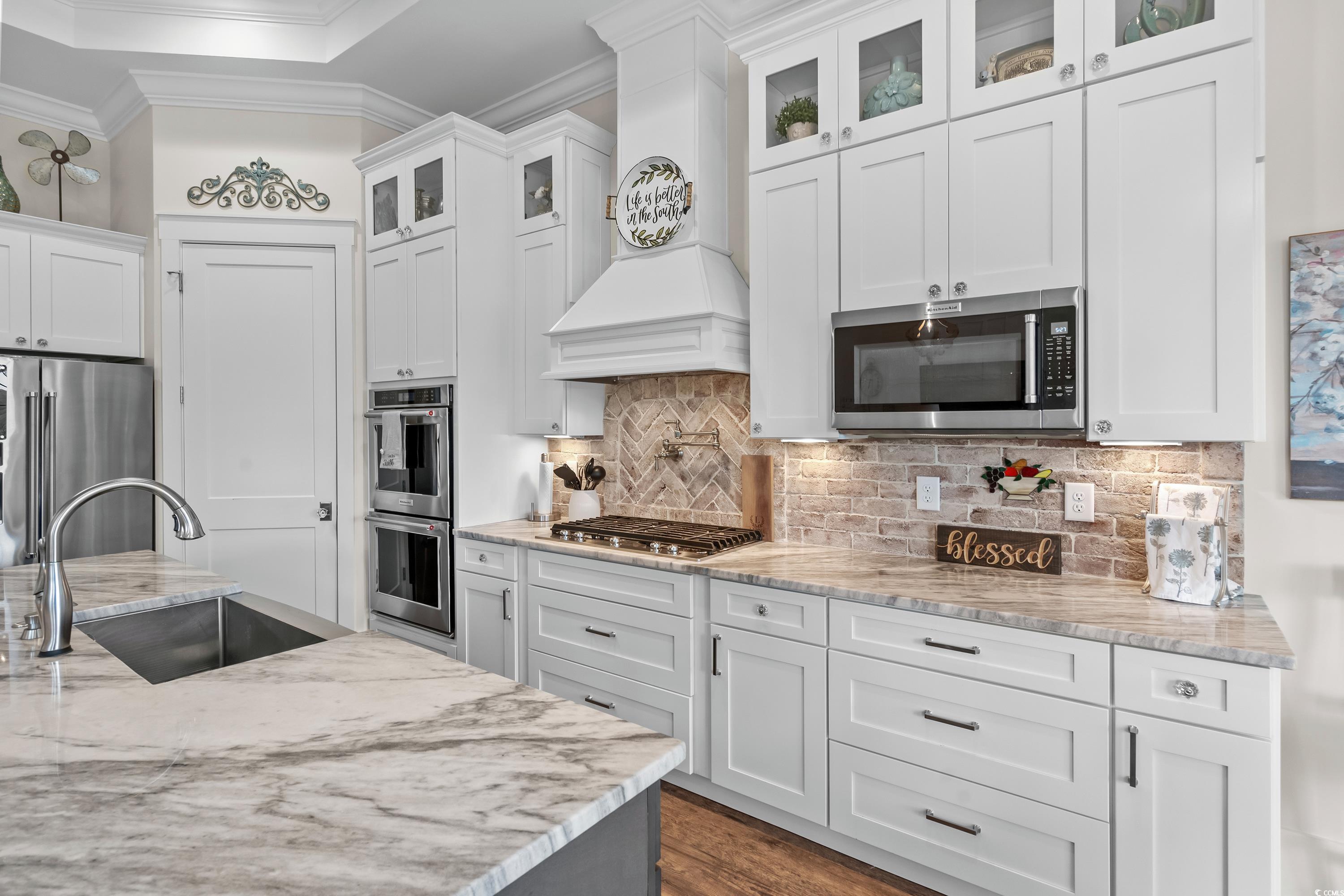 348 Chamberlin Road Myrtle Beach, SC 29588 - Photo 18 of 40 Kitchen featuring white cabinets, backsplash, stai