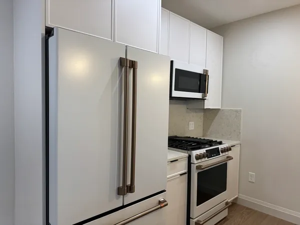 a metallic refrigerator freezer sitting in a kitchen