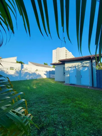 a backyard of a house with lots of green space and plants