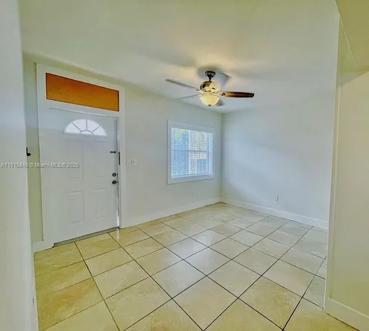 a view of an empty room and chandelier fan