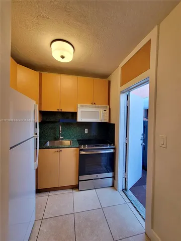 a kitchen with stainless steel appliances granite countertop a refrigerator and a stove