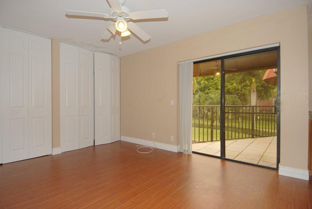8122 Severn Drive, Unit A Boca Raton, FL 33433 - Photo 14 of 30 a view of empty room with wooden floor and fan