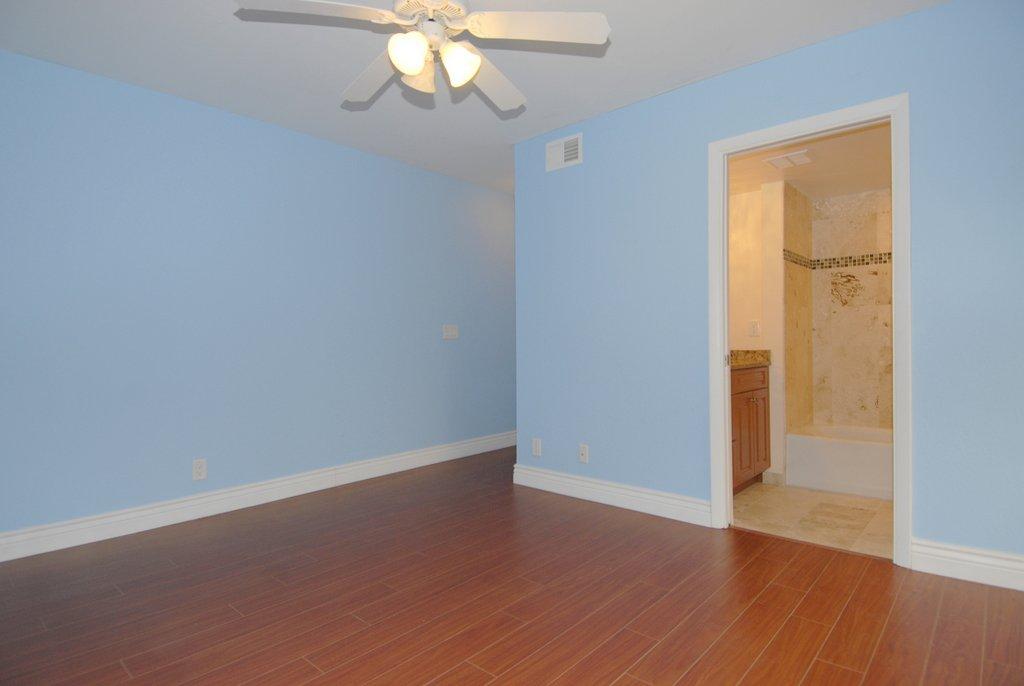 8122 Severn Drive, Unit A Boca Raton, FL 33433 - Photo 18 of 30 an empty room with wooden floor and windows