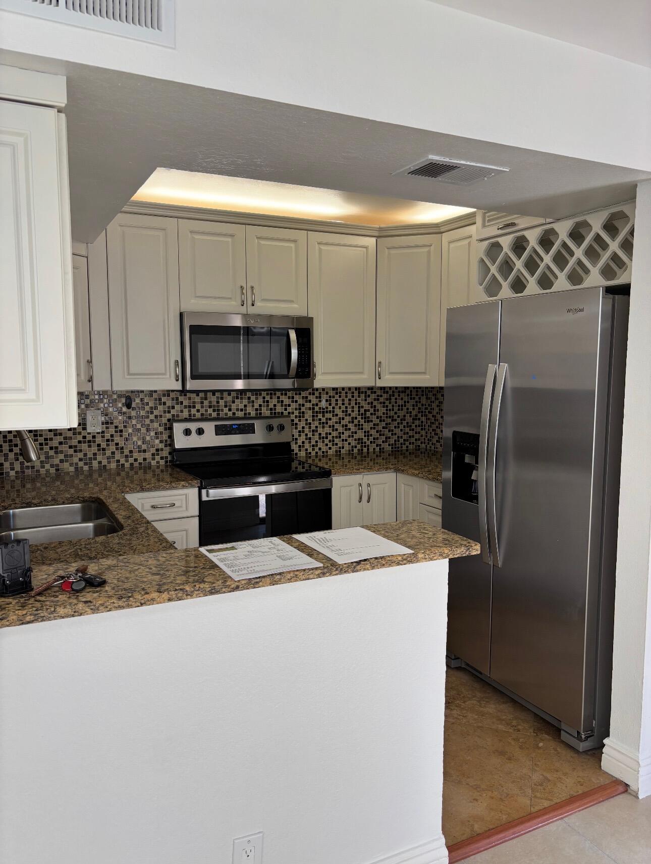 8122 Severn Drive, Unit A Boca Raton, FL 33433 - Photo 8 of 30 a kitchen with granite countertop a refrigerator and a sink