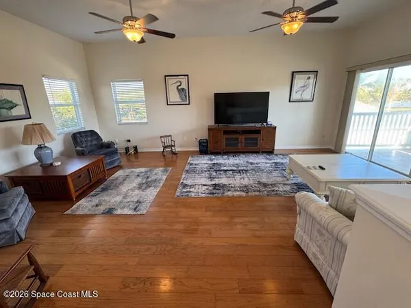 a kitchen with stainless steel appliances granite countertop a refrigerator a stove a sink dishwasher and white cabinets with wooden floor