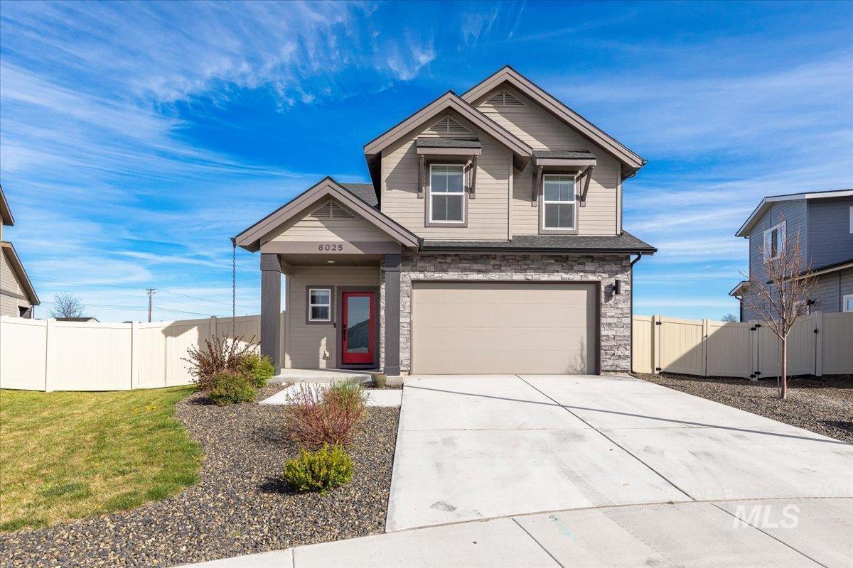 Craftsman-style home with driveway, stone siding, and an attached garage