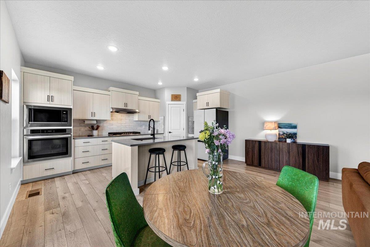 6025 South Catria Place Meridian, ID 83642 - Photo 13 of 34 Dining room featuring light wood-style flooring, recessed lighting, and a textured ceiling